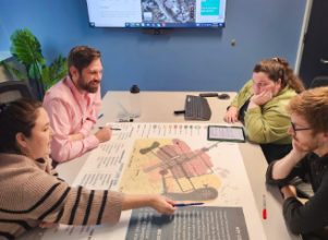 Team of Halff's Austin employees that are recent grads and entry level collaborating at a table